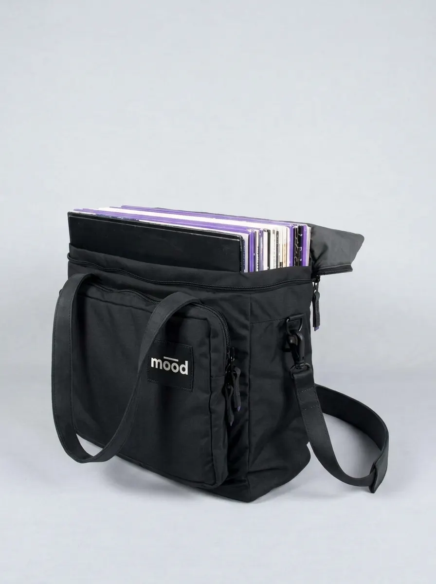 Bolso negro para discos de 12 pulgadas, abierto y lleno de discos, con parche mood blanco en el bolsillo delantero.